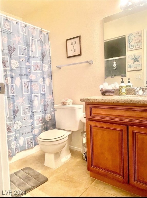 bathroom with a shower with curtain, vanity, toilet, and tile patterned floors