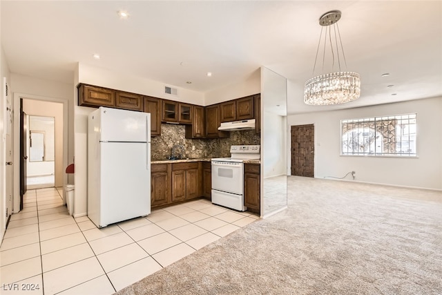 kitchen with pendant lighting, white appliances, backsplash, sink, and light colored carpet