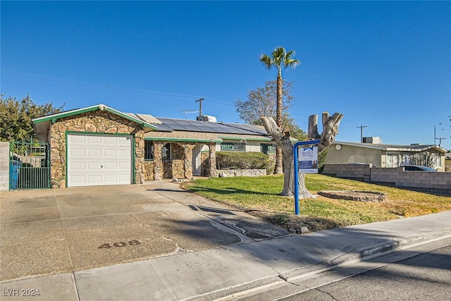 ranch-style home with a front lawn, a garage, and solar panels