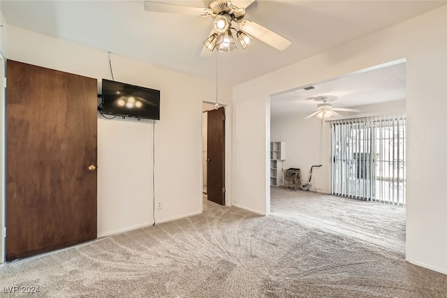 carpeted spare room featuring ceiling fan