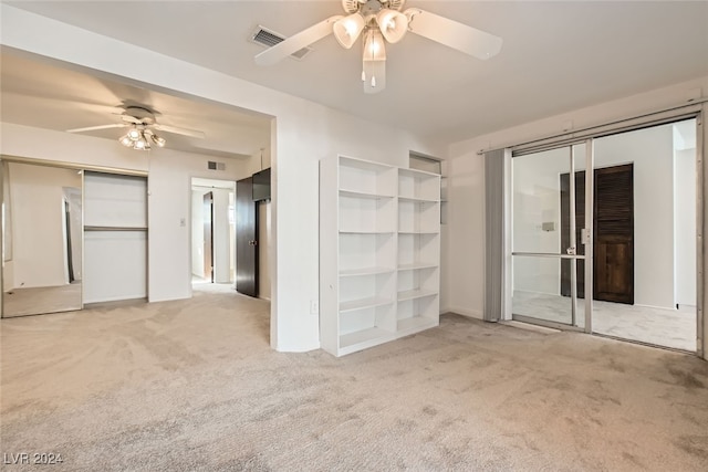 interior space with ceiling fan and light colored carpet