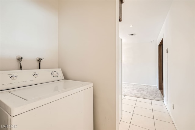 clothes washing area with light tile patterned floors and washer / clothes dryer