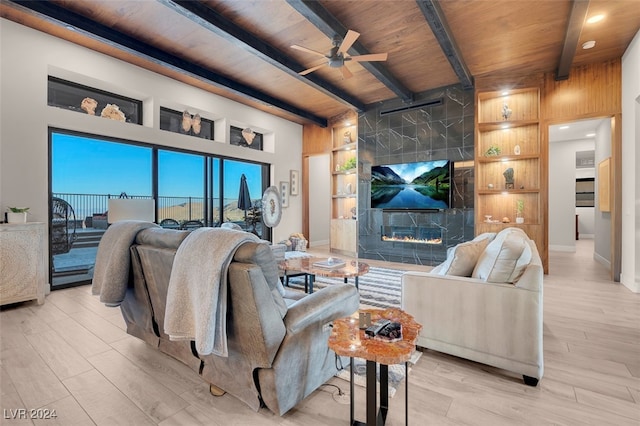 living room featuring beam ceiling, built in features, light hardwood / wood-style flooring, and wood ceiling