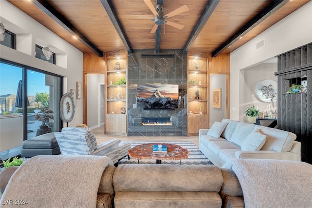 living room featuring wood ceiling, beamed ceiling, wood-type flooring, and built in shelves