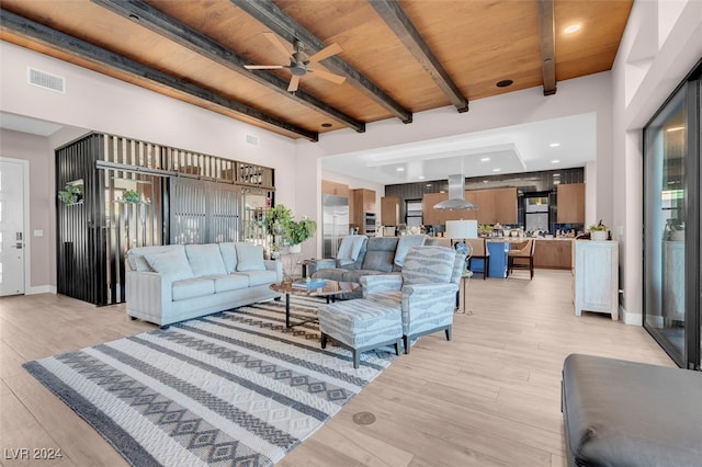 living room featuring ceiling fan, wooden ceiling, beamed ceiling, a towering ceiling, and light hardwood / wood-style floors