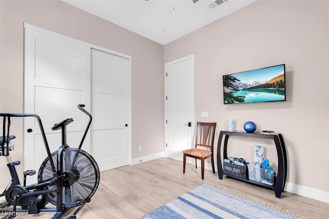 exercise room with light hardwood / wood-style flooring