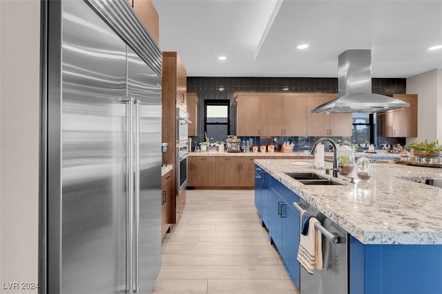 kitchen featuring sink, island range hood, light hardwood / wood-style floors, stainless steel appliances, and a kitchen island with sink