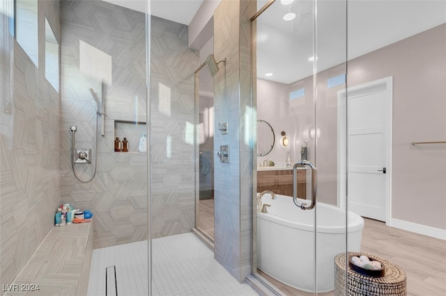 bathroom with shower with separate bathtub and hardwood / wood-style flooring