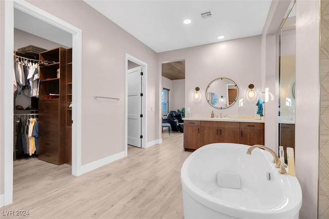 bathroom with vanity, hardwood / wood-style floors, and a washtub