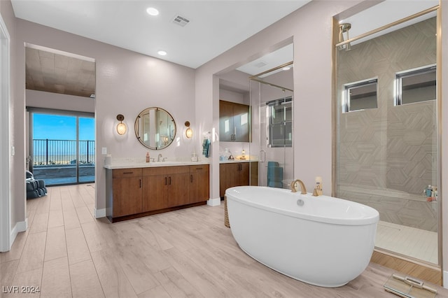 bathroom featuring vanity, shower with separate bathtub, and hardwood / wood-style flooring