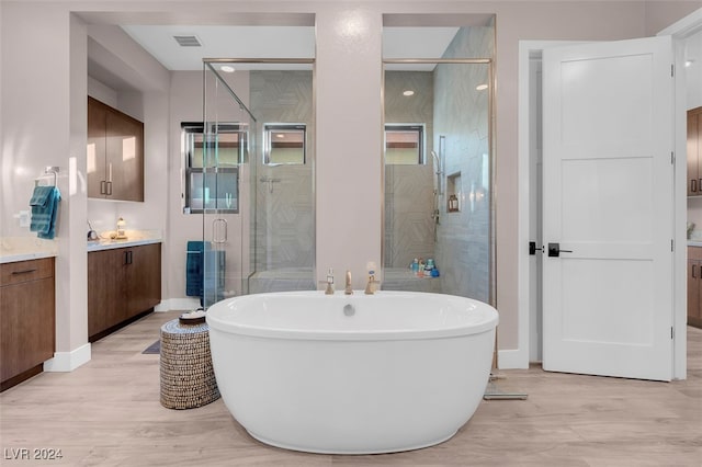 bathroom with vanity, plus walk in shower, and hardwood / wood-style flooring