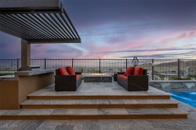 patio terrace at dusk with an outdoor living space and pool water feature