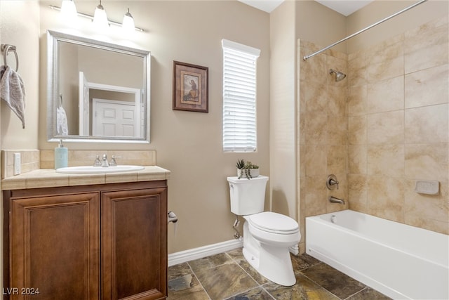 full bathroom with tiled shower / bath, vanity, and toilet