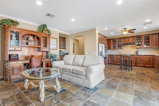 living room with ornamental molding and ceiling fan