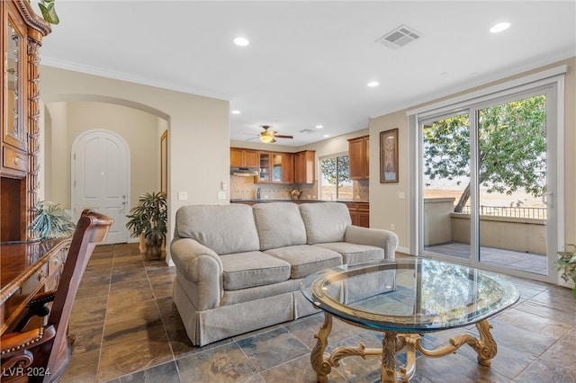 living room with ceiling fan and ornamental molding