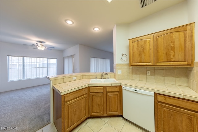 kitchen with white dishwasher, sink, kitchen peninsula, backsplash, and light colored carpet