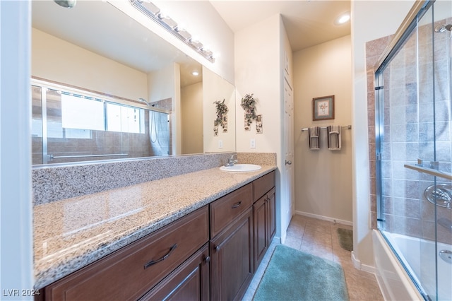 bathroom featuring vanity, tile patterned floors, and bath / shower combo with glass door