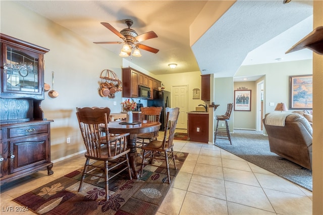 dining space featuring a textured ceiling, ceiling fan, and light tile patterned floors