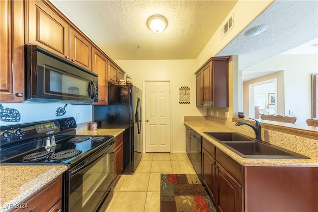 kitchen featuring black appliances, sink, a textured ceiling, light stone counters, and light tile patterned floors