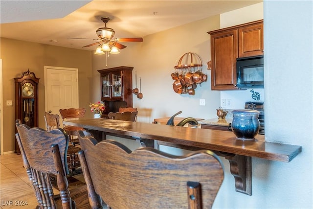 3550 Bay Sands Dr Unit 2082, Laughlin, NV 89029 - kitchen featuring black microwave, ceiling fan, brown cabinetry, and light tile patterned flooring