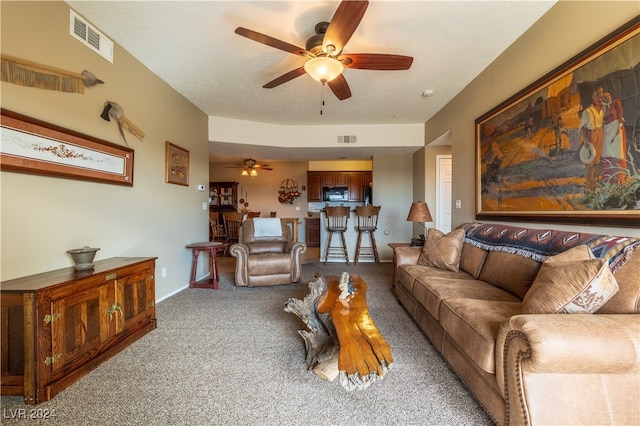 living room featuring carpet flooring and ceiling fan