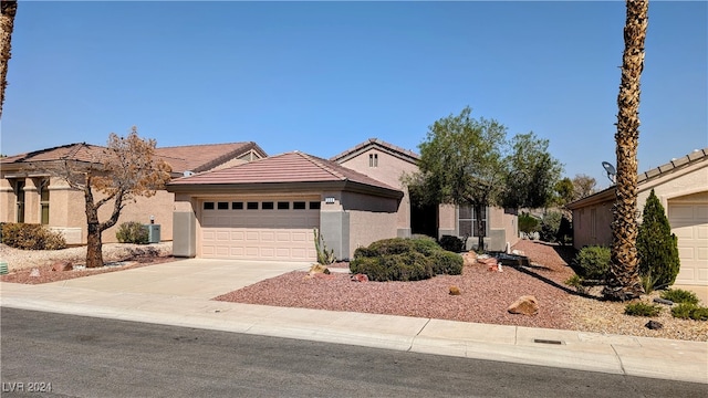 view of front of house with a garage and central AC