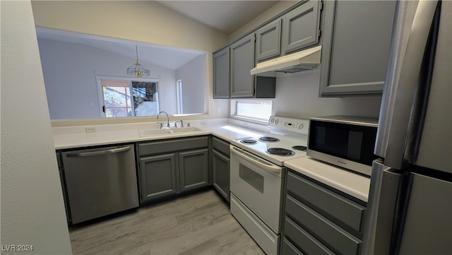 kitchen with gray cabinets, appliances with stainless steel finishes, sink, and lofted ceiling