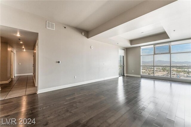 unfurnished room with a mountain view and dark hardwood / wood-style floors