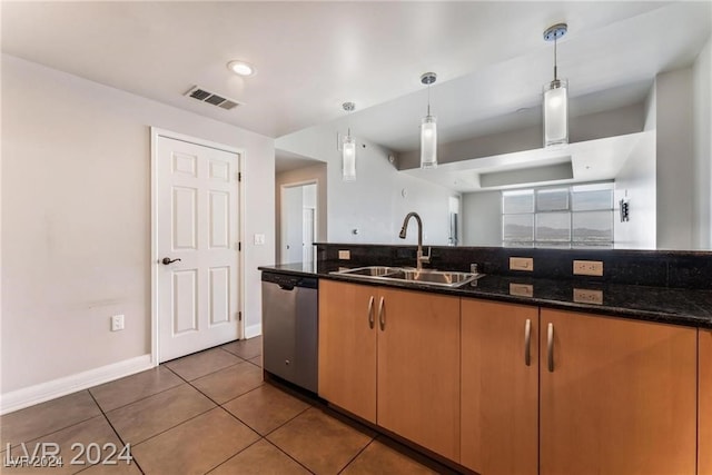 kitchen with dishwasher, dark tile patterned floors, decorative light fixtures, dark stone counters, and sink