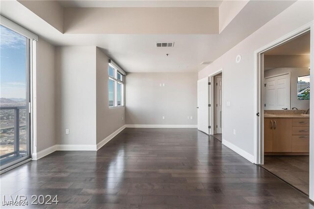 unfurnished room with dark wood-type flooring and a healthy amount of sunlight