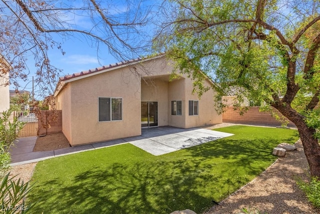 back of house with a patio area and a lawn