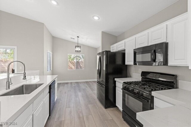 kitchen featuring a healthy amount of sunlight, black appliances, sink, and vaulted ceiling