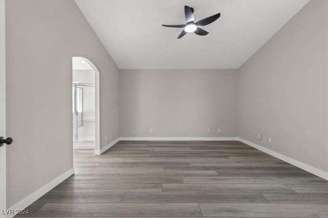 unfurnished room with hardwood / wood-style flooring, ceiling fan, and vaulted ceiling