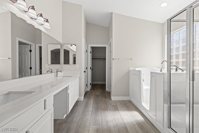 bathroom with walk in shower, lofted ceiling, hardwood / wood-style flooring, and vanity