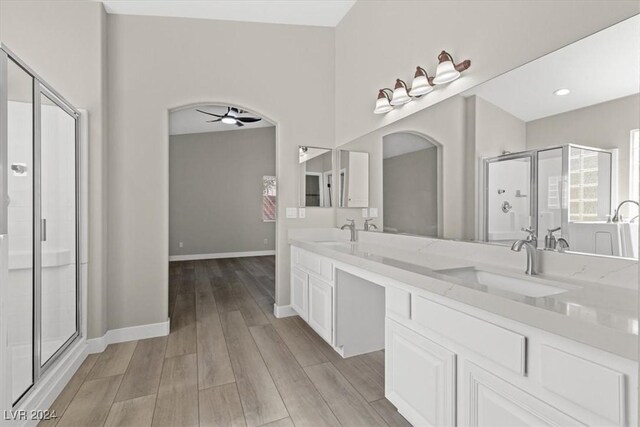 bathroom with walk in shower, vanity, hardwood / wood-style floors, and ceiling fan