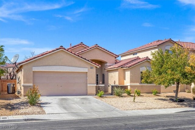 view of front of property featuring a garage and cooling unit