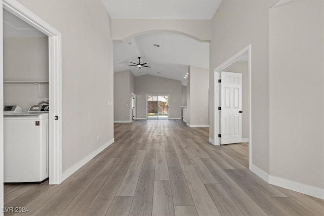 corridor with washer and dryer, light wood-type flooring, and vaulted ceiling