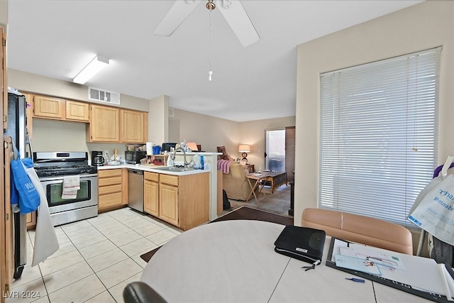 kitchen with ceiling fan, sink, light tile patterned floors, appliances with stainless steel finishes, and light brown cabinetry