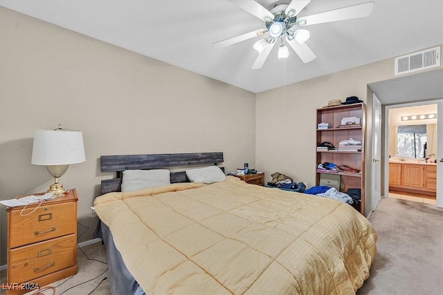 bedroom featuring ceiling fan, light carpet, and ensuite bathroom