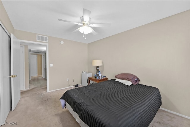 bedroom featuring light carpet, a closet, and ceiling fan