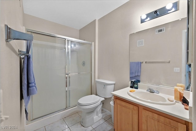 bathroom featuring vanity, toilet, tile patterned floors, and a shower with shower door