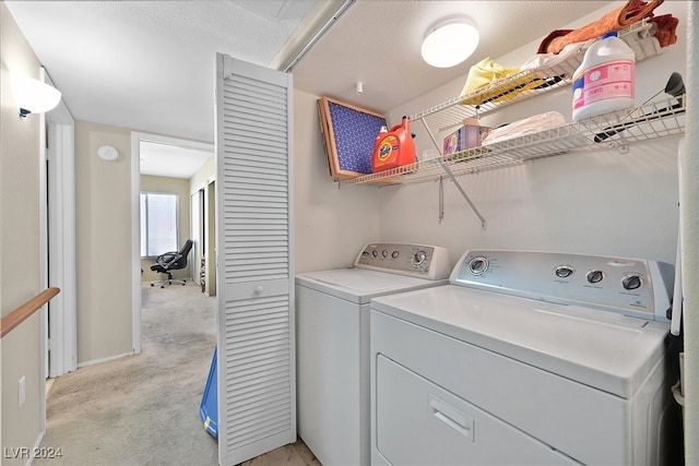 laundry room featuring light carpet, a textured ceiling, and washer and dryer