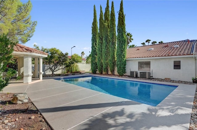 view of pool featuring a patio and central AC unit