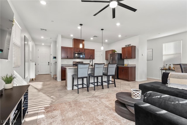 tiled living room with ceiling fan and sink