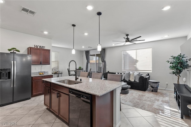 kitchen with stainless steel fridge, black dishwasher, decorative light fixtures, a center island with sink, and sink