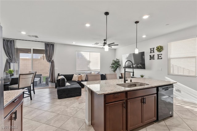 kitchen featuring hanging light fixtures, light tile patterned flooring, black dishwasher, light stone countertops, and sink