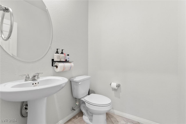 bathroom featuring toilet, sink, and tile patterned floors