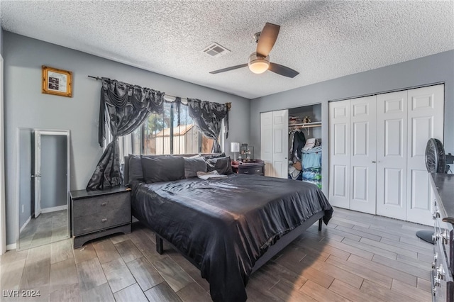 bedroom featuring light hardwood / wood-style floors, ceiling fan, and a textured ceiling