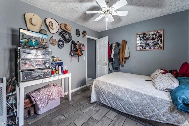 bedroom featuring ceiling fan, a textured ceiling, and wood-type flooring