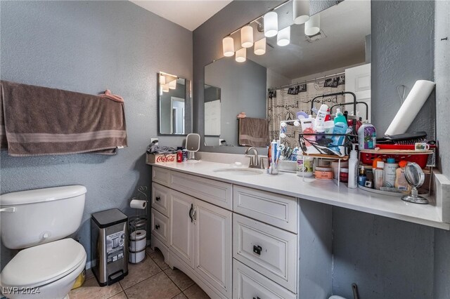 bathroom with curtained shower, vanity, toilet, and tile patterned floors